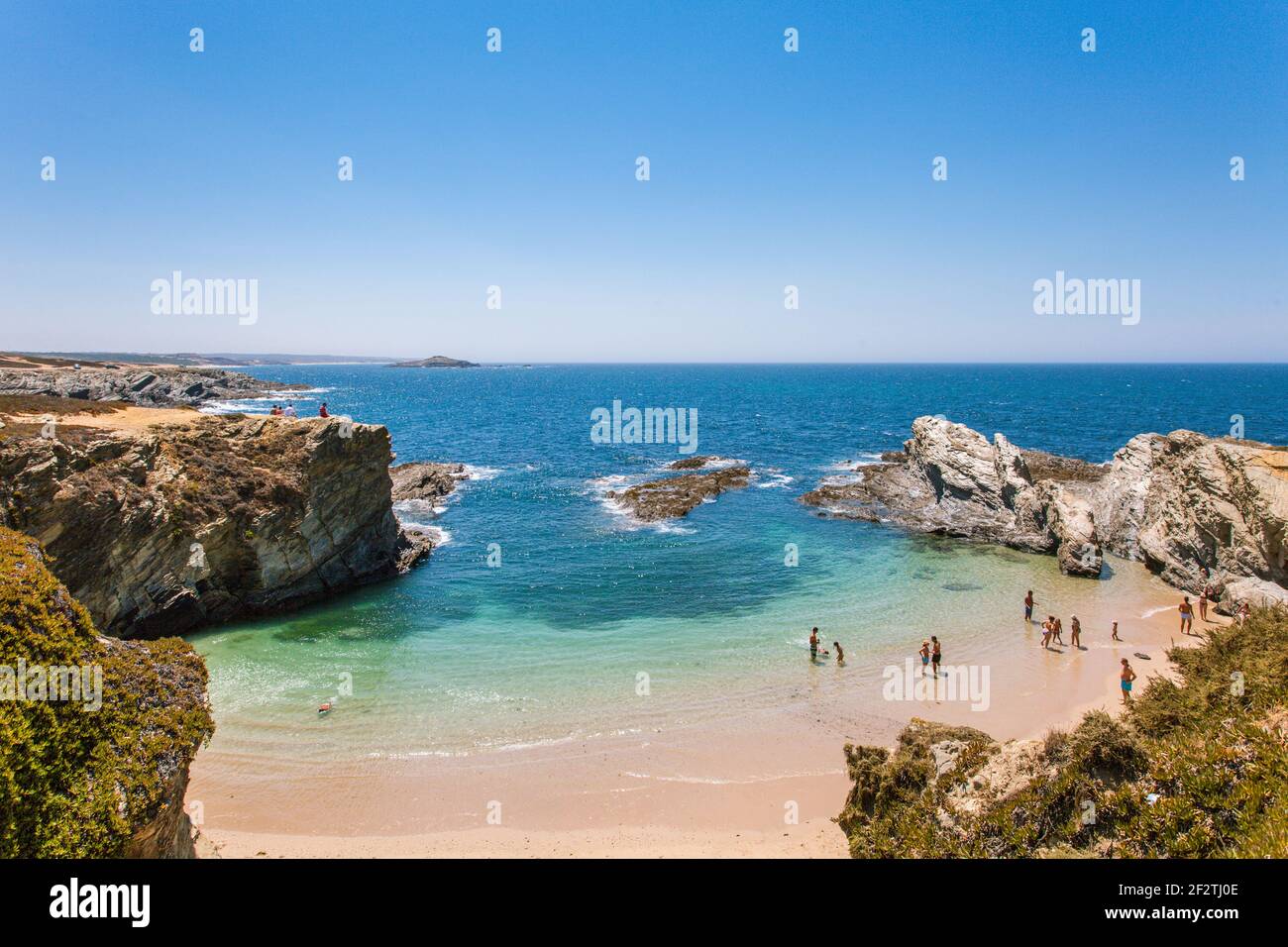 I turisti che si godono il sole e il clima caldo sulla baia della spiaggia di Praia dos Buizinhos, Porto Covo, Alentejo - Portogallo. Foto Stock