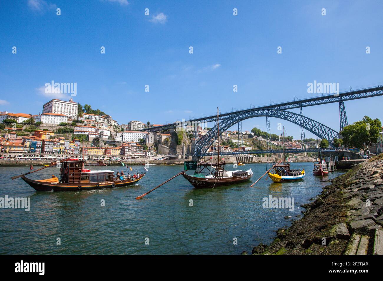 Chiatte sul fiume Douro a Porto, con l'iconico ponte Dom Luis sullo sfondo. Foto Stock