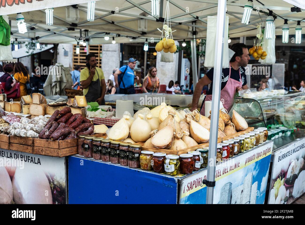 Napoli, Italia - 9 settembre 2019: Venditore in un negozio di formaggi e salsicce in un mercato di Street food con persone in giro in Via Toledo, Napoli, Italia Foto Stock