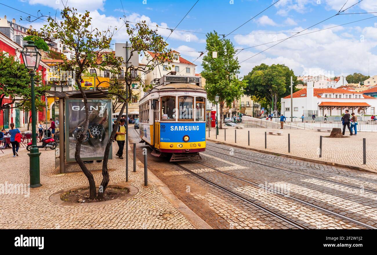 Tram alla sua fermata e turisti in via Sao Tome Nel distretto di Alfama di Lisbona in Portogallo Foto Stock