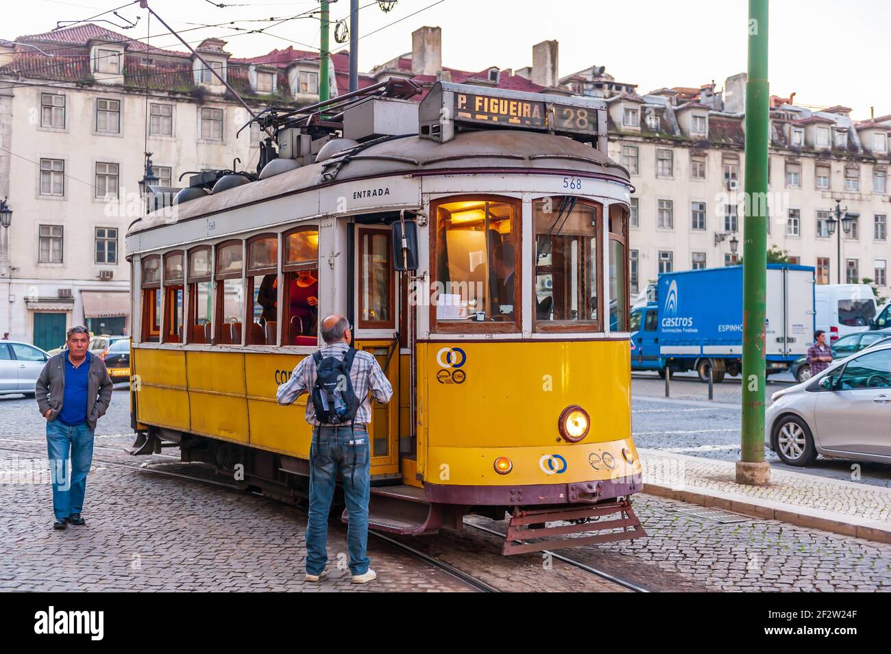 Tram alla sua fermata e turisti in via Sao Tome Nel distretto di Alfama di Lisbona in Portogallo Foto Stock