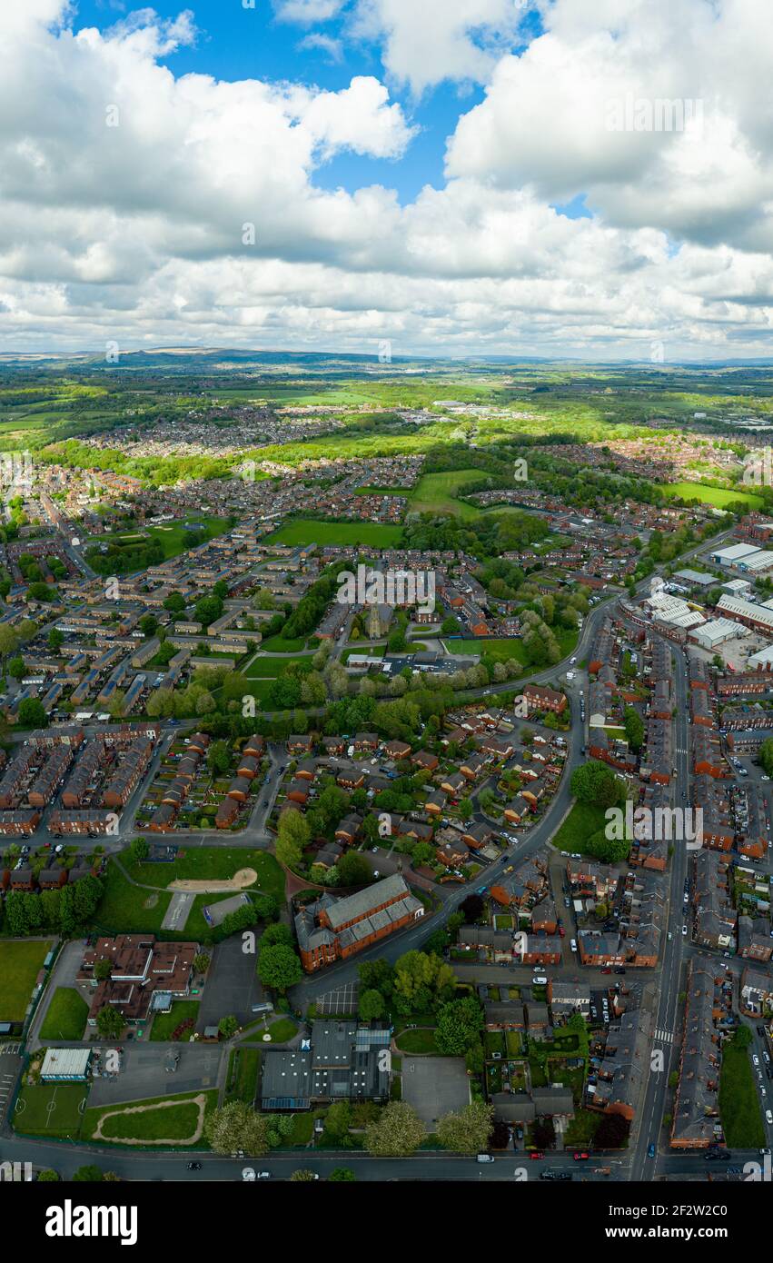 Foto aerea di una tipica proprietà immobiliare britannica nella grande città di Wigan, che mostra una vista dall'alto del drone di strade suburbane, strade e file di hous Foto Stock