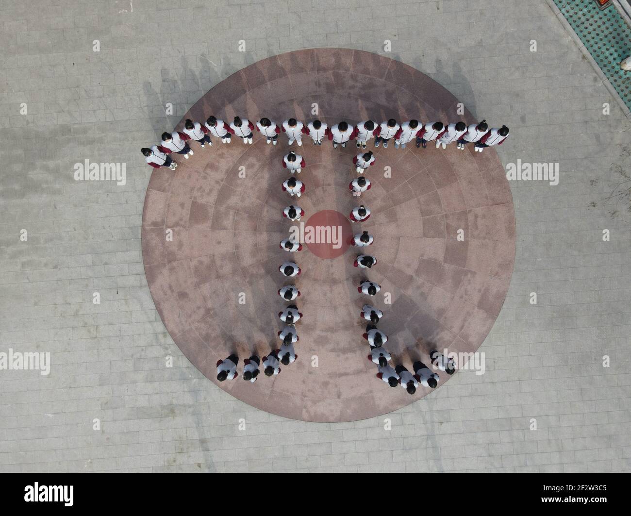 (210313) -- BAODING, 13 marzo 2021 (Xinhua) -- Foto aerea scattata il 13 marzo 2021 mostra gli studenti della Scuola superiore Zu Chongzhi in piedi in una formazione della lettera greca 'Pi' durante un evento commemorativo di Zu Chongzhi in vista del giorno del Pi nella contea di Laishui, nella provincia di Hebei nella Cina settentrionale. Il 14 marzo è celebrato in tutto il mondo come Pi Day, poiché 3, 1 e 4 sono le prime tre cifre significative della costante matematica che denota il rapporto tra la circonferenza di un cerchio e il suo diametro. Zu Chongzhi, matematico e astronomo cinese del V secolo, aveva fatto un notevole realizzo Foto Stock