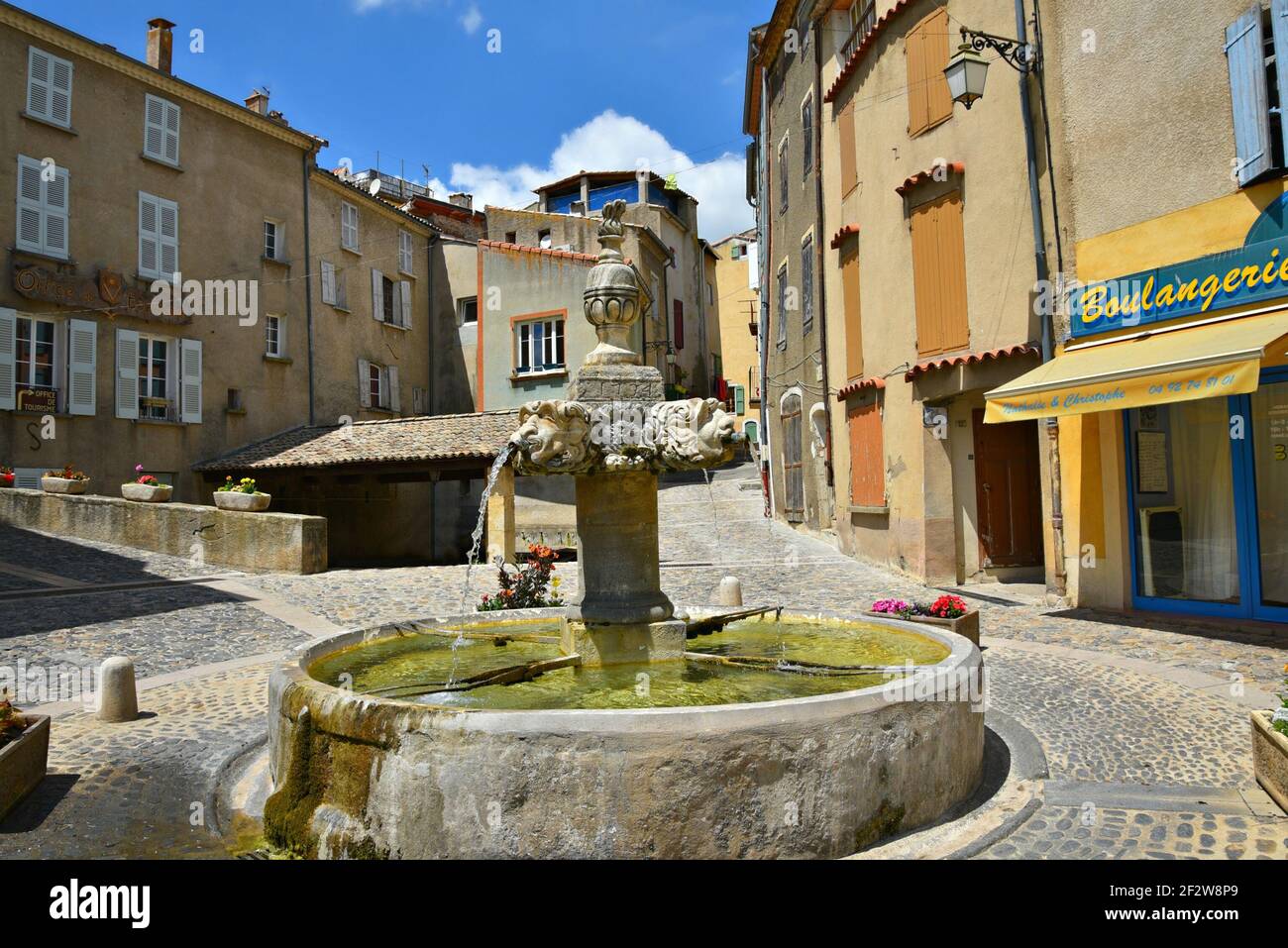 Case in stile Provençal e negozi locali sulla piazza principale del centro storico di Valensole, nelle Alpi dell'alta Provenza, Francia. Foto Stock