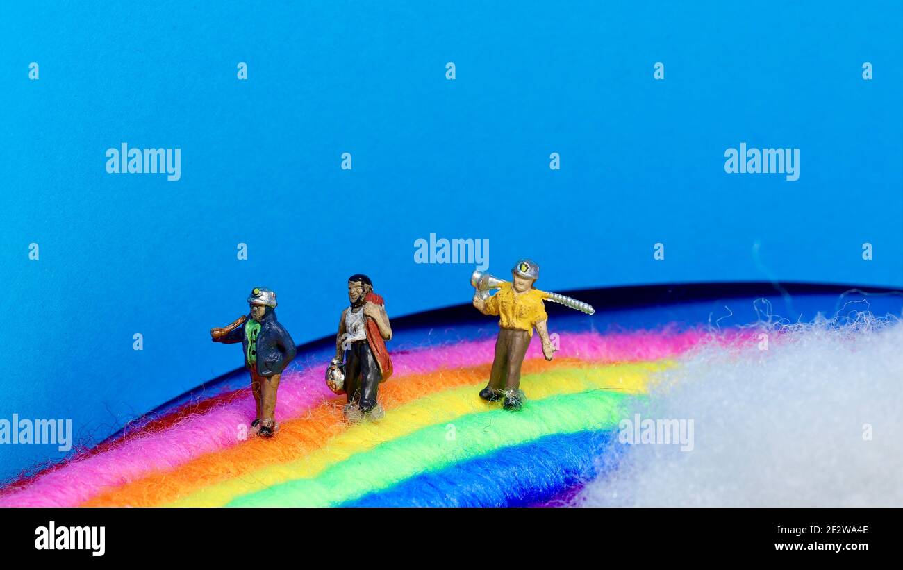Tre minatori mini modello sperano di trovare una pentola d'oro alla fine dell'arcobaleno. Foto Stock