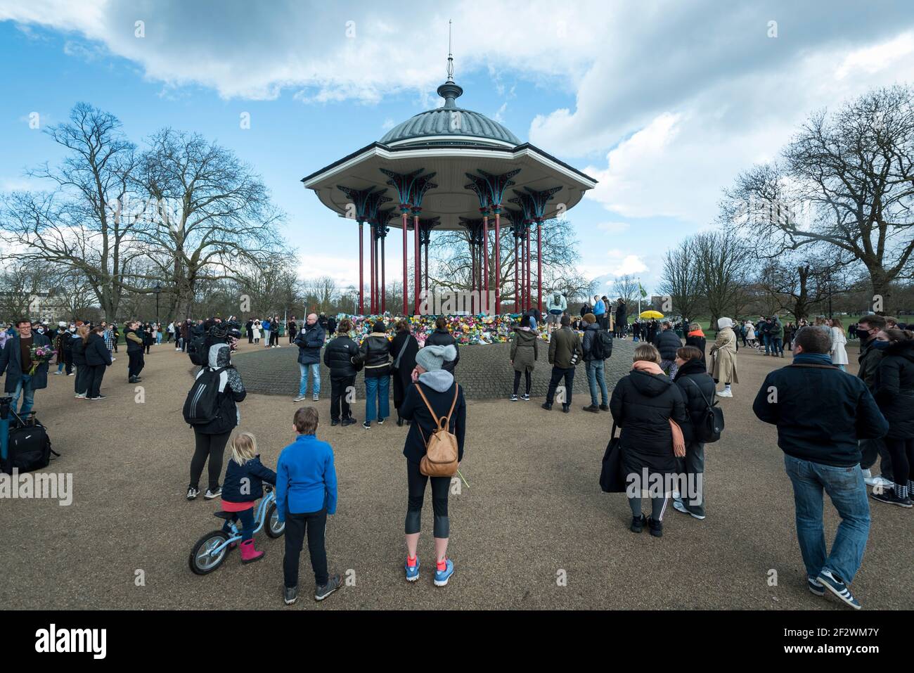 Londra, Regno Unito. 13 marzo 2021. La gente guarda i tributi floreali alla tribuna sul Clapham Common per ricordare Sarah Everard. Wayne Couzens, 48 anni, un ufficiale di polizia incontrato, è stato accusato del suo rapimento e assassinio dopo che ha camminato a casa vicino a Clapham Common nel sud di Londra. Il corpo di 33 anni è stato trovato nel bosco del Kent più di una settimana dopo l'ultima avvistata il 3 marzo. Credit: Stephen Chung / Alamy Live News Foto Stock