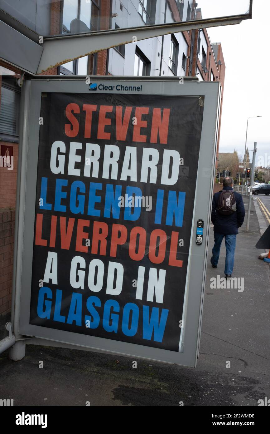 Glasgow, Regno Unito, il 13 marzo 2021. I poster che celebrano la vittoria del titolo di Premier scozzese dello scorso fine settimana da parte dei Rangers Football Club, il loro 55° titolo di questo tipo, e proclamano il loro manager, Steven Gerrard, un ‘Dio’, sono apparsi sui rifugi degli autobus nella zona sud della città. Sembrerebbe che la campagna del manifesto sia una campagna di guerriglia, con uso non autorizzato degli spazi pubblicitari. Photo credit: Jeremy Sutton-Hibbert/Alamy Live News. Foto Stock