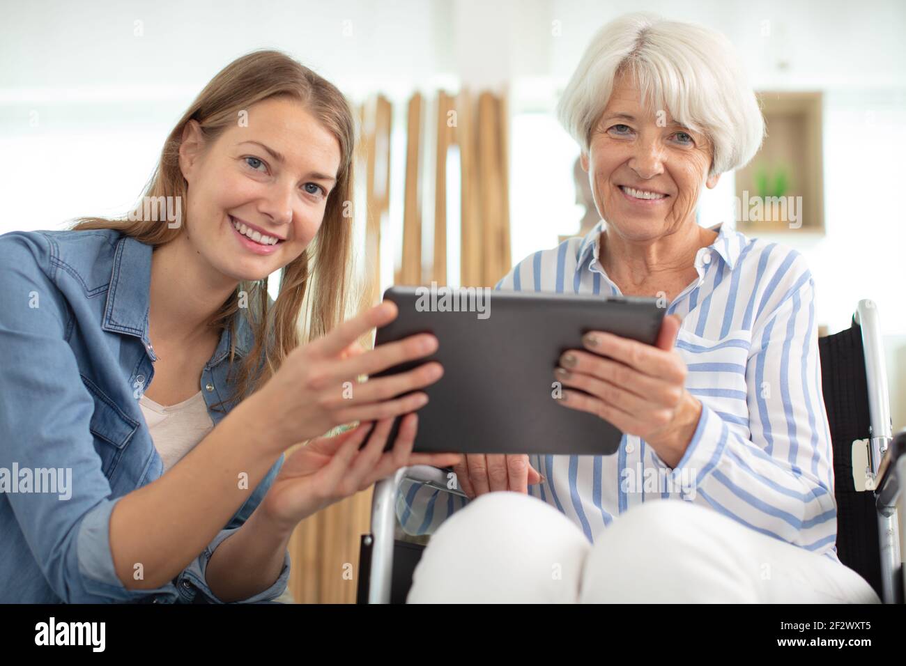 donna anziana e sua figlia adulta che usa la tavoletta Foto Stock