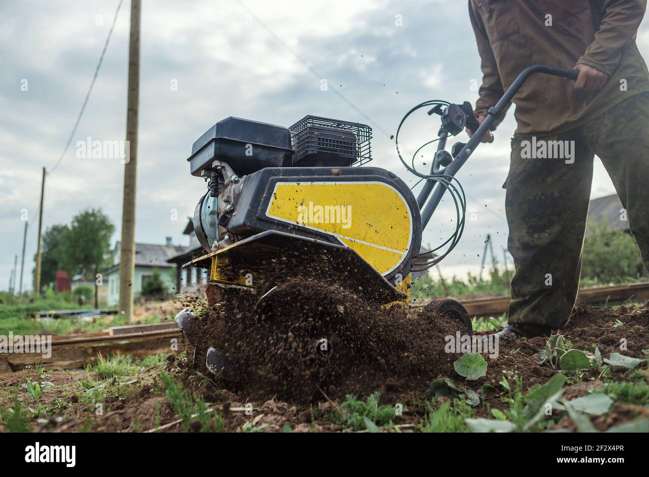 Un uomo aratura intensamente il suo orto da motocoltivatore Foto stock -  Alamy