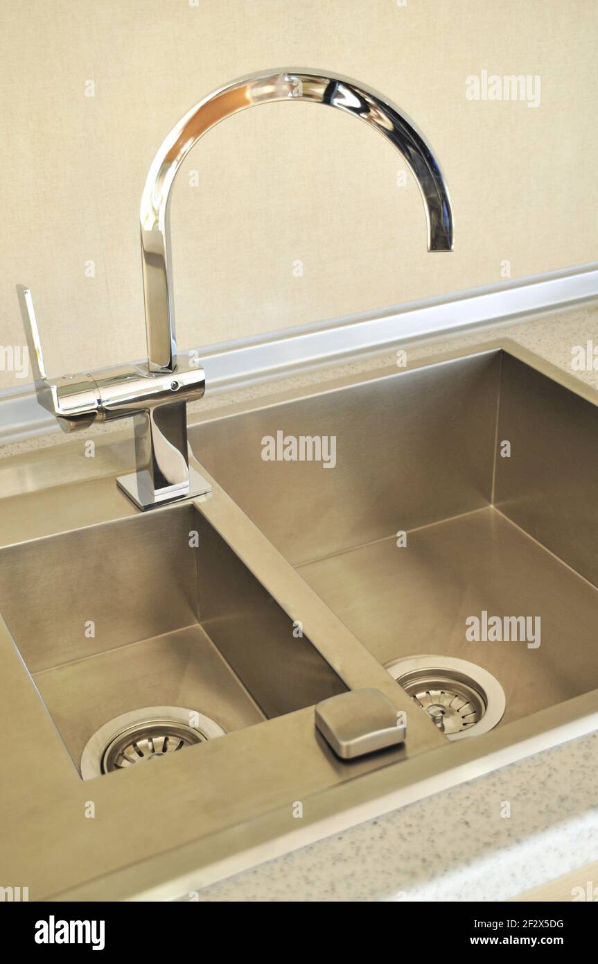 Interno di lussuosa cucina moderna e lavandino, rubinetto e scarico in acciaio inossidabile Foto Stock