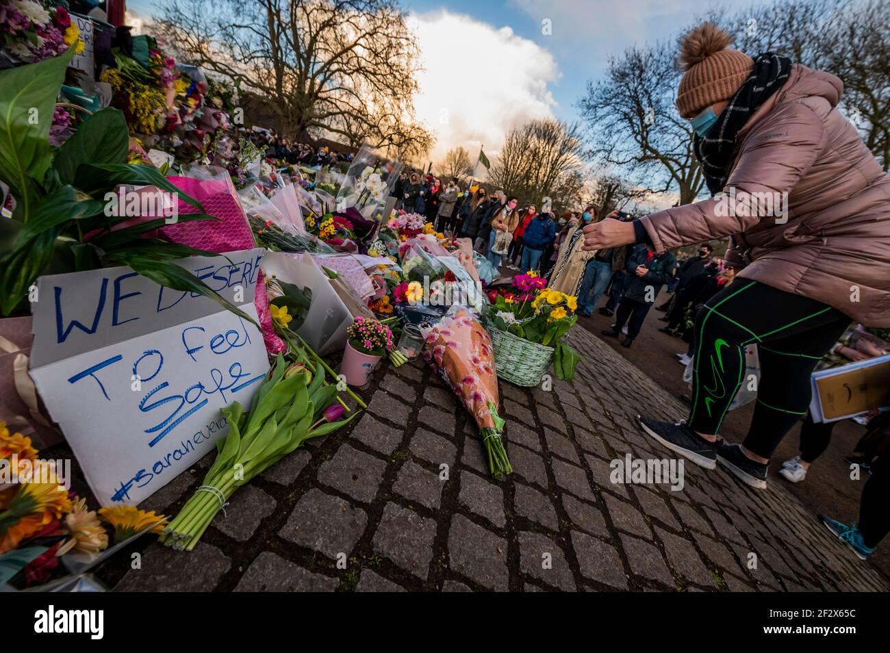 Londra, Regno Unito. 13 Marzo 2021. Le persone si riuniscono per lasciare fiori e tributi per Sarah Everard in una veglia presso la Bandstand dove previsto. Nonostante sia stato vietato dalla polizia in base a norme covide. Scomparve dopo le 9:00 del 3 marzo da qualche parte tra Clapham Junction e Brixton. Credit: Guy Bell/Alamy Live News Foto Stock