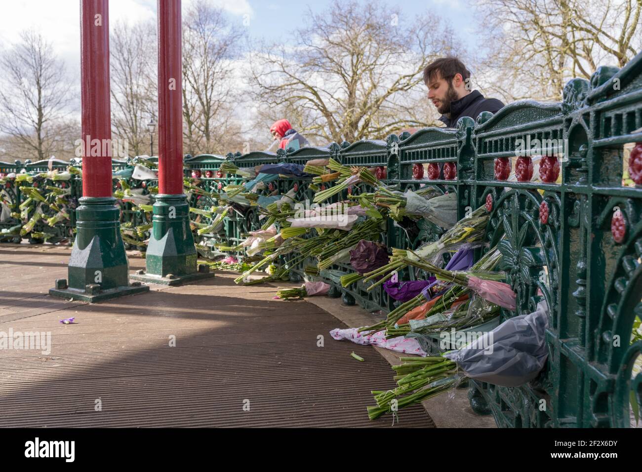 L'uomo presenta tributi floreali al chiosco Clapham Common in memoria di Sarah Everard, rapito e assassinato, Londra, Inghilterra Foto Stock