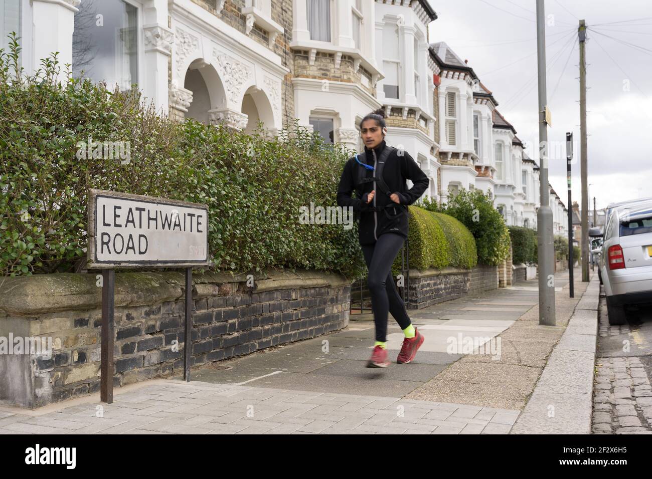 Una donna corre su Leathwaite Road, vicino a Clapham Common, a sud di Londra, dove Sarah Everard è stata vista l'ultima volta prima di essere rapita e uccisa nel Kent UK Foto Stock