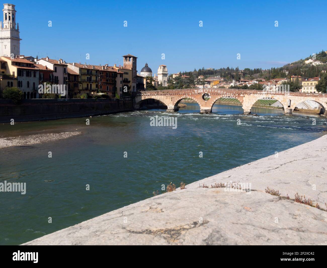 Il Ponte di pietra, il più antico ponte di Verona, è un ponte ad arco romano che attraversa il fiume Adige. Sotto il ponte, l'acqua b Foto Stock