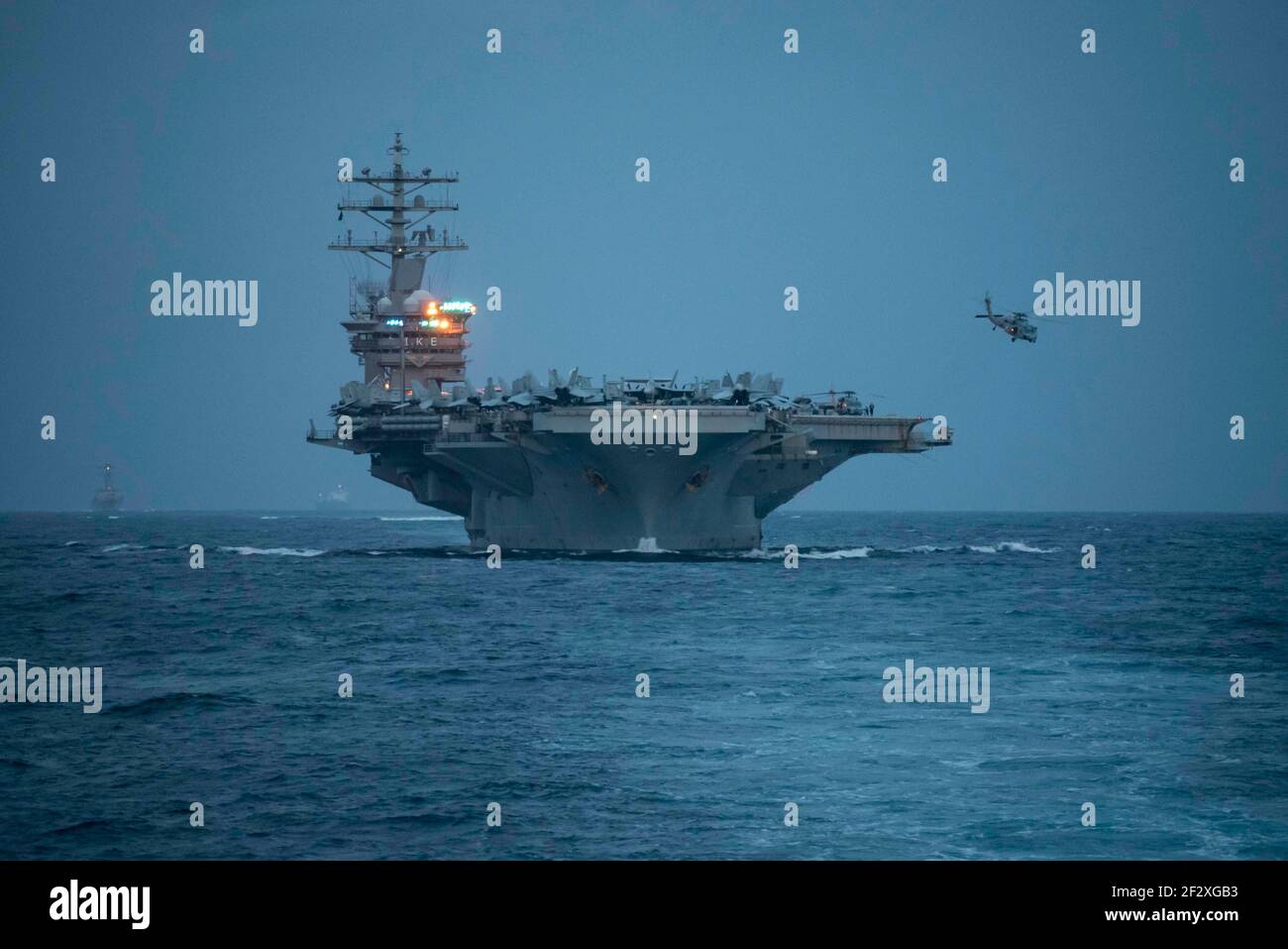 Un elicottero della marina statunitense Sea Hawk lancia il ponte di volo della portaerei di classe Nimitz USS Dwight D. Eisenhower mentre transita nello stretto di Gibilterra in un dispiegamento di routine nella sesta area di attività della flotta il 9 marzo 2021 nel Mar Mediterraneo. Foto Stock