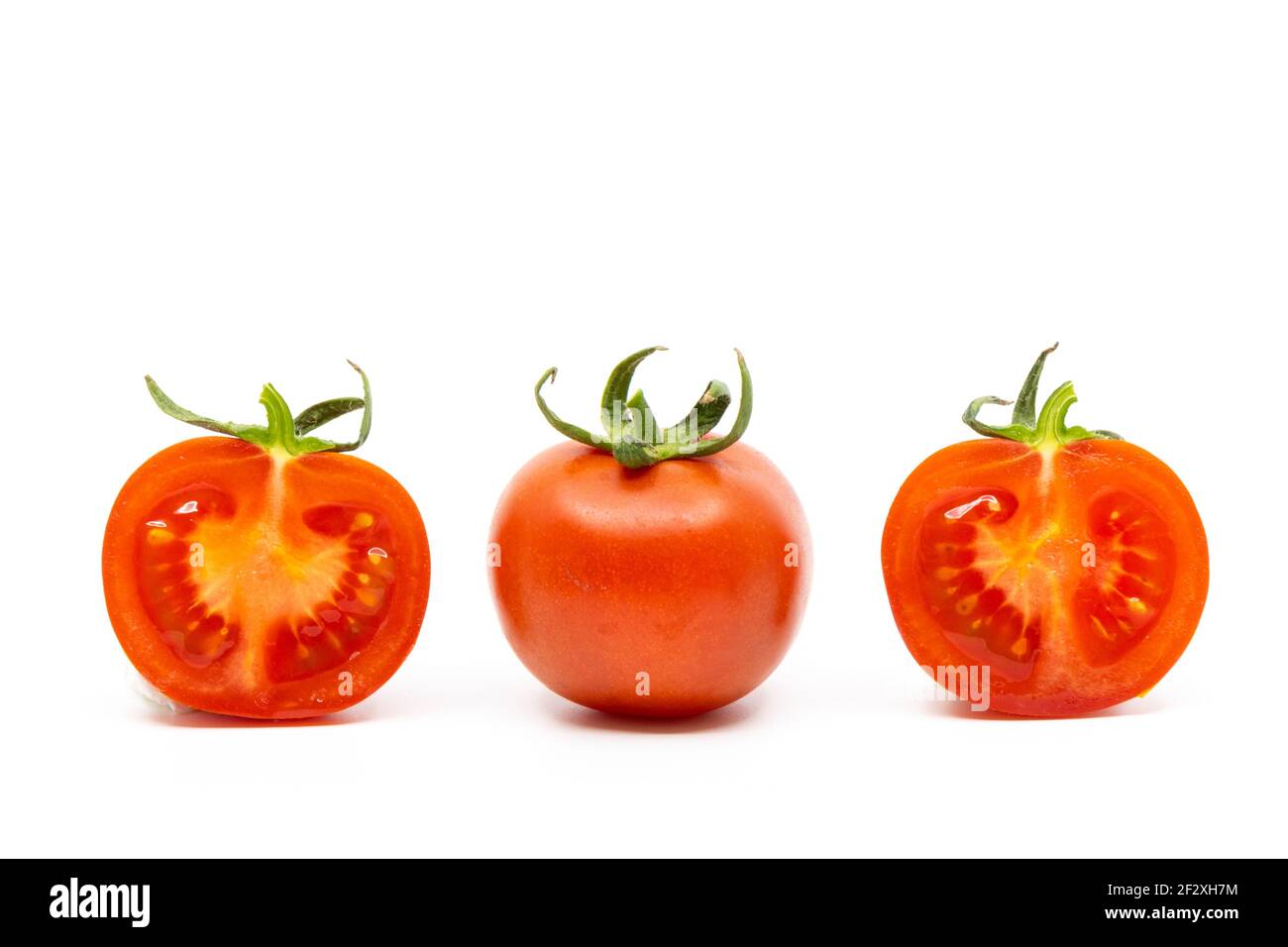 Pomodoro intero e due metà di pomodori isolati su bianco Sfondo Foto Stock