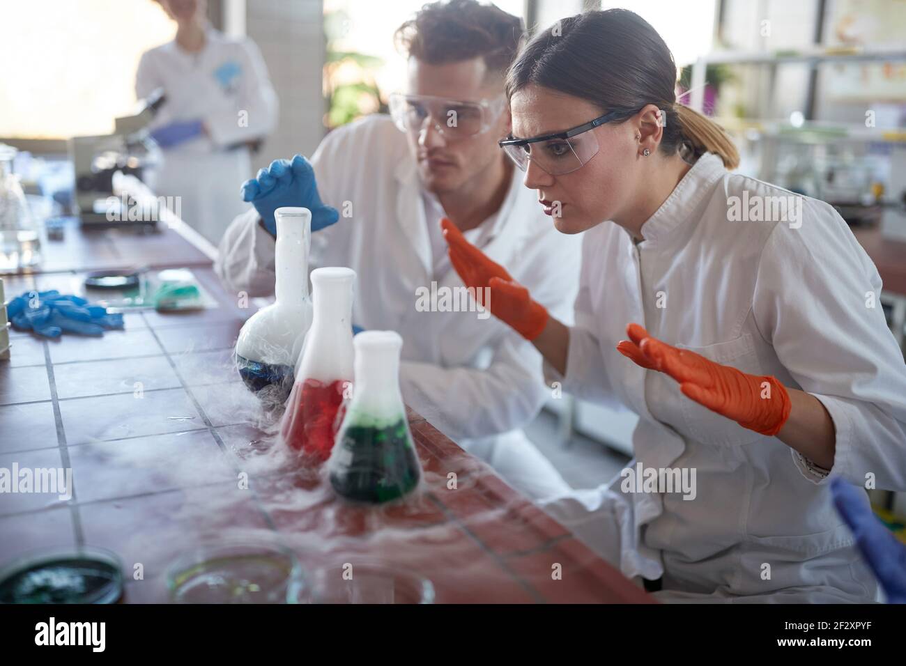 Colleghi ricercatori che analizzano insieme le reazioni chimiche Foto Stock