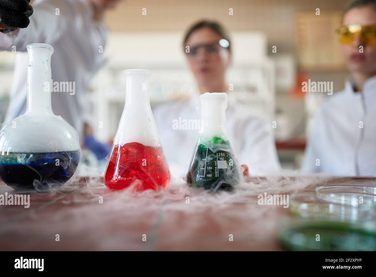 I tecnici di laboratorio che effettuano esperimenti di reazioni chimiche in laboratorio Foto Stock