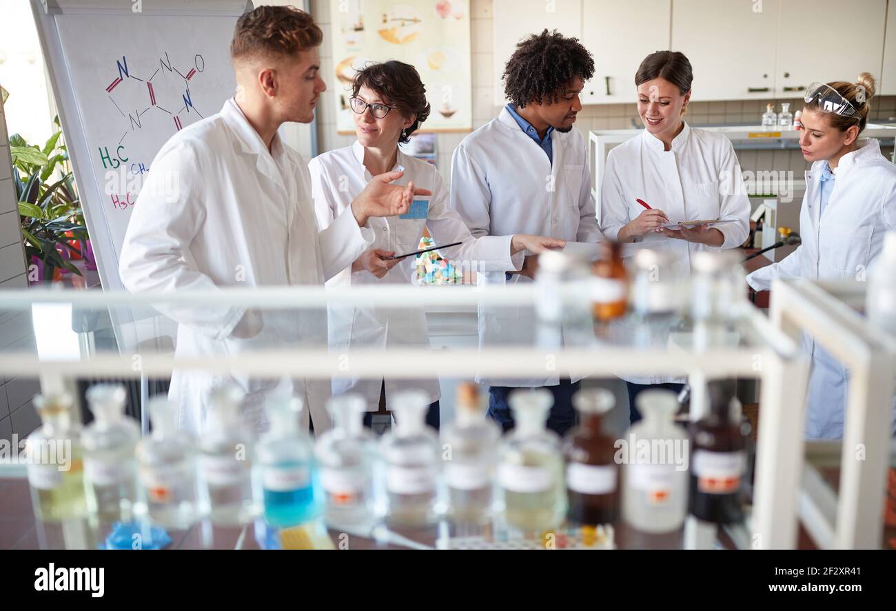 Team di giovani tecnici di laboratorio che discutono i risultati in laboratorio Foto Stock