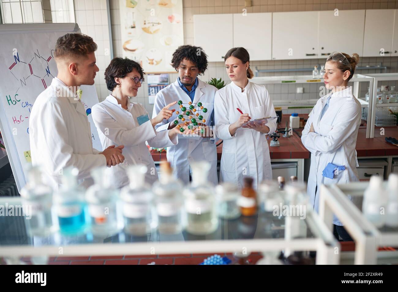 Giovani studenti di sostanze chimiche imparano sul modello delle molecole in un'atmosfera rilassata nel laboratorio universitario. Scienza, chimica, laboratorio, persone Foto Stock