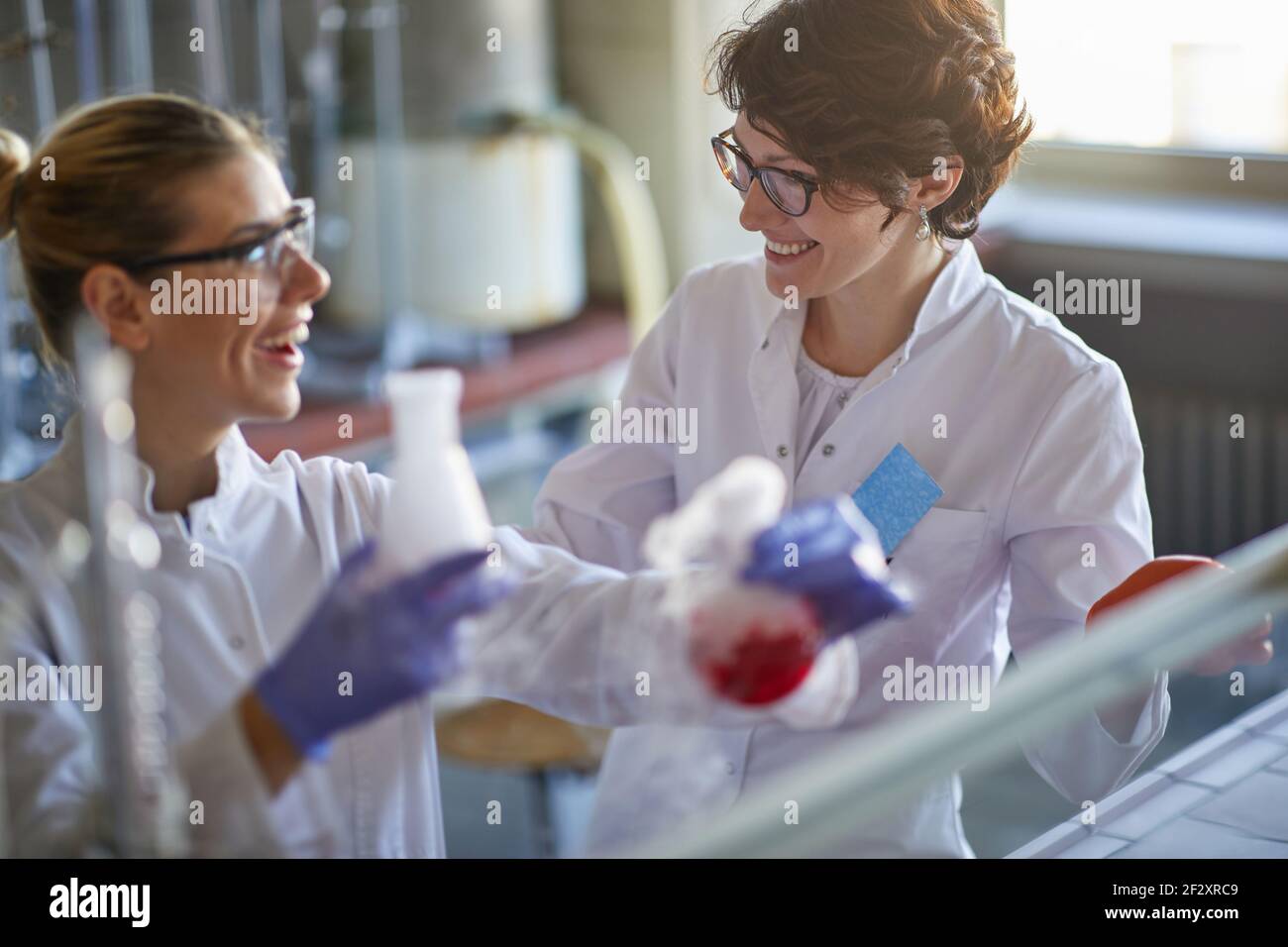 Due lavoranti femminili che analizzano insieme i campioni in laboratorio Foto Stock
