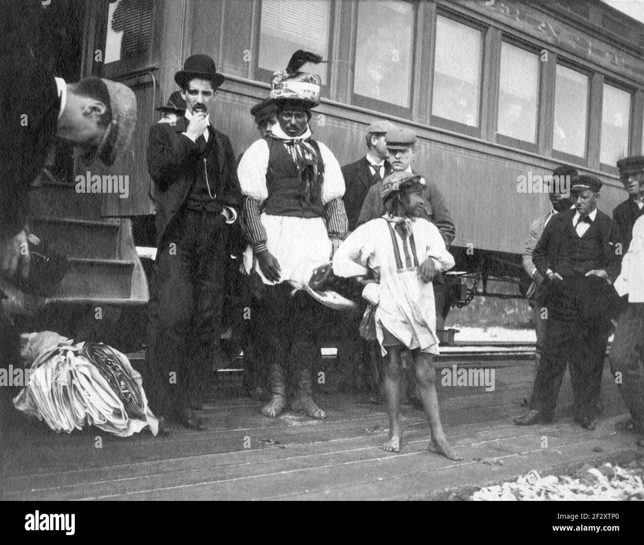 Billy BowLegs III, noto anche come Billy Fewell o Cofehapkee (1862–1965), anziano di Seminole (anche di discendenza afroamericana) e storico tribale, in piedi con altri uomini accanto a un treno a ft. Pierce, Florida, nel 1896. BowLegs era il nipote di Osceola ed era un membro del clan di serpente. Foto Stock