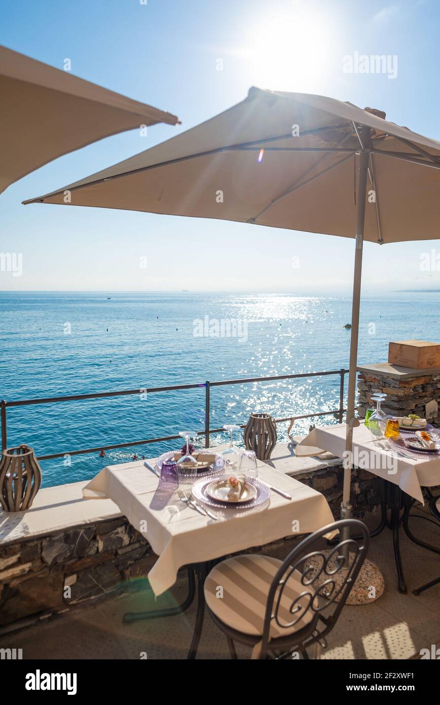 Tavolo per due persone in un ristorante affacciato sul mare Ligure a Camogli, Italia. E 'stagione estiva e non c'è alcun divaricamento sociale ai tavoli Foto Stock