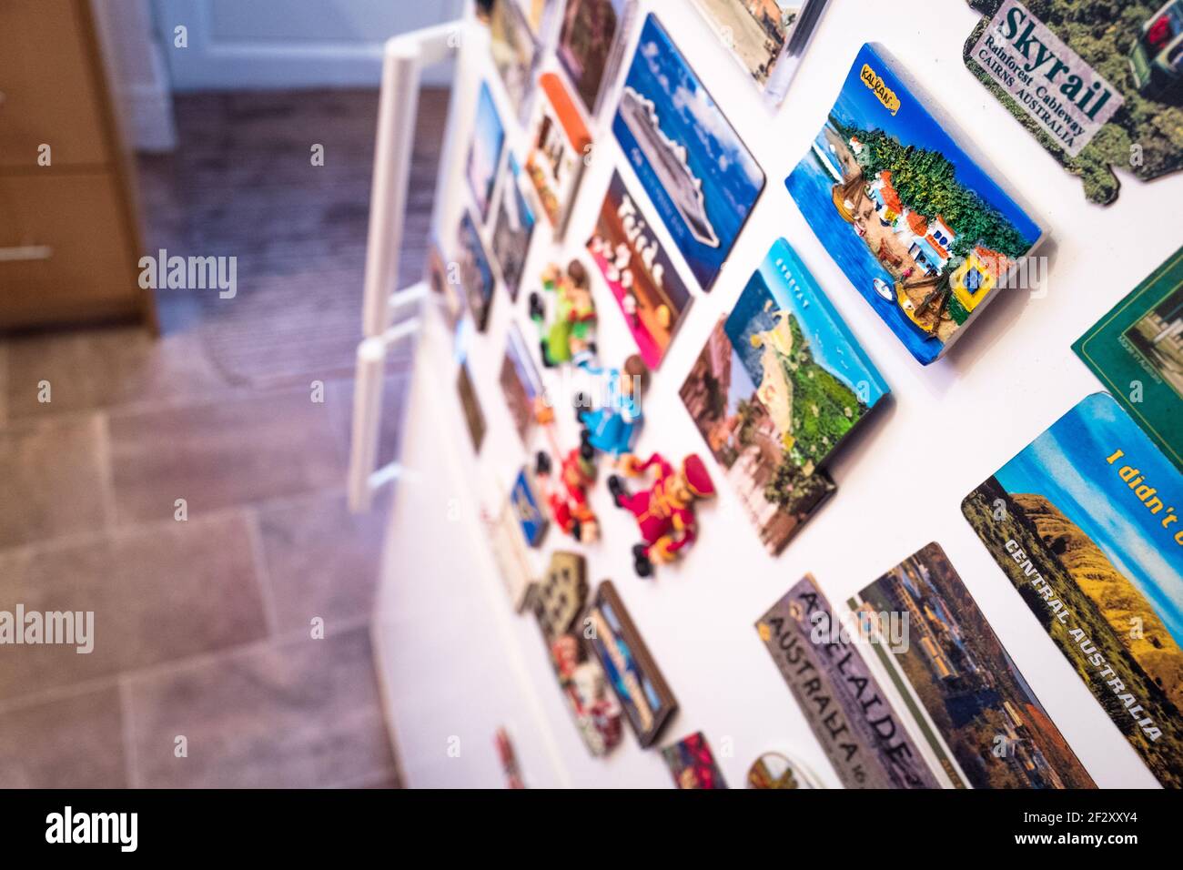 Assortimento di magneti per frigoriferi su una porta per frigoriferi. Foto Stock