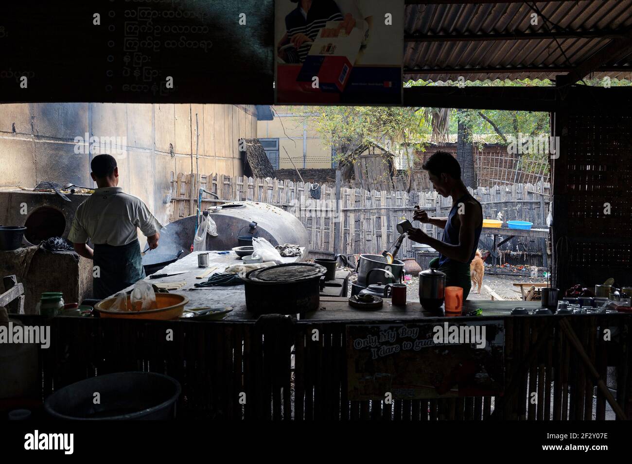 Due uomini che cucinano cibo al ristorante Nyaung U (Nyaung Oo) Marketplace (mani Sithu) a Nyaung U, vicino a Bagan Myanmar (Birmania) Foto Stock