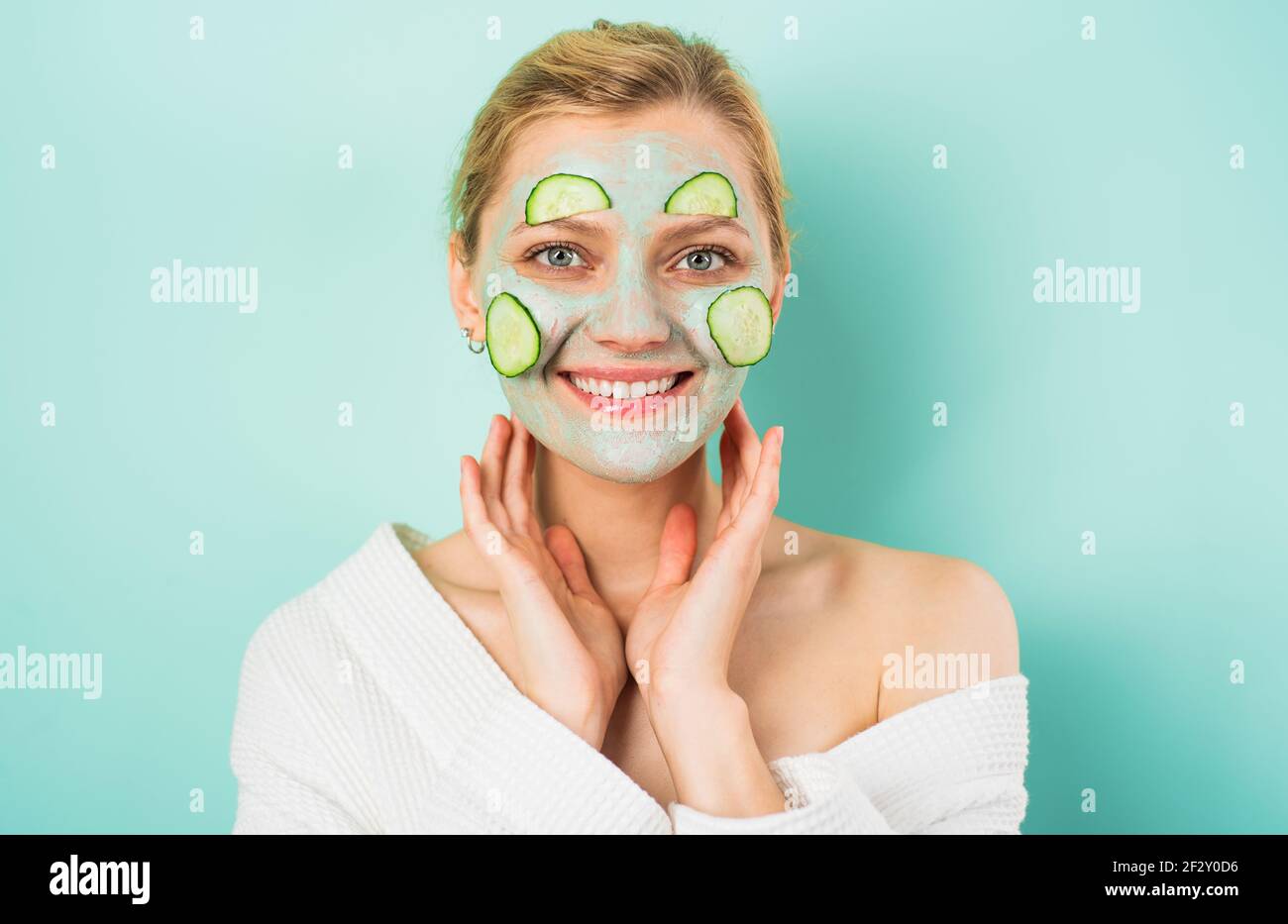 Bella donna con maschera per la cura del viso e fettine di cetrioli. Procedura cosmetica. Trattamenti di bellezza. Dermatologia. Foto Stock
