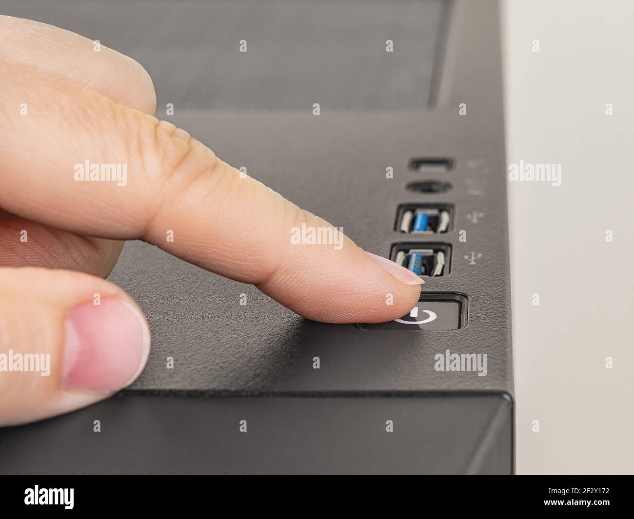 Il dito è pronto a premere verso il basso il pulsante on off sull'unità di sistema del personal computer. Pulsante di accensione nella parte superiore del telaio tower del PC desktop. Primo piano. Foto Stock