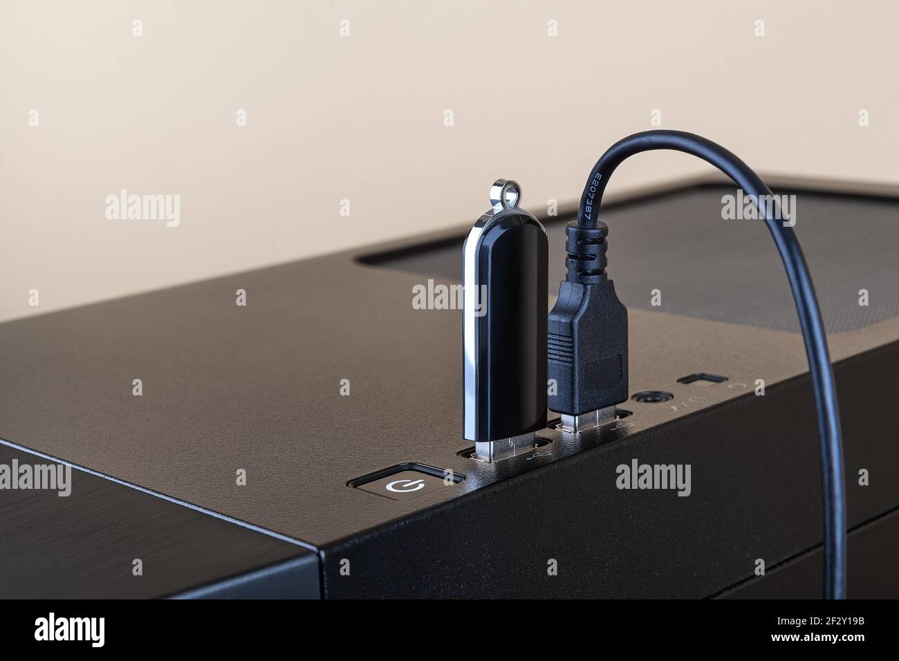 L'unità flash USB e il cavo USB sono entrambi inseriti nelle porte sulla parte superiore del case tower del computer. Dispositivo di trasferimento e memorizzazione delle informazioni. Connettori USB. Foto Stock