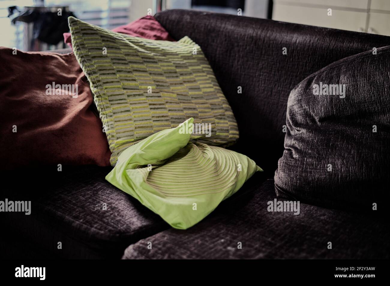 Immagine ad alto contrasto di cuscini verdi su un divano in regolazione interna Foto Stock