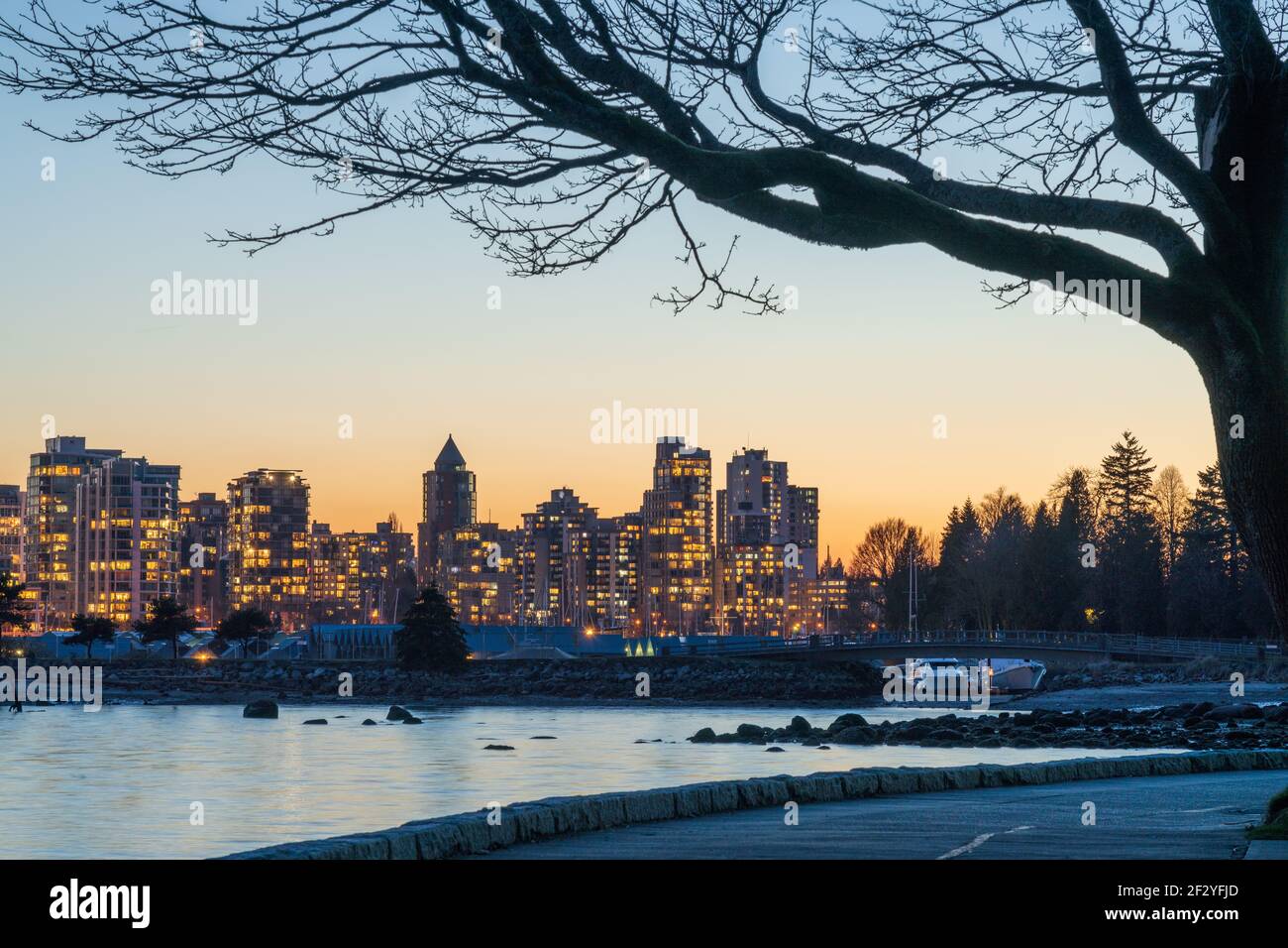 Stanley Park Seawall al tramonto. Skyline del centro di Vancouver sullo sfondo. British Columbia, Canada. Foto Stock