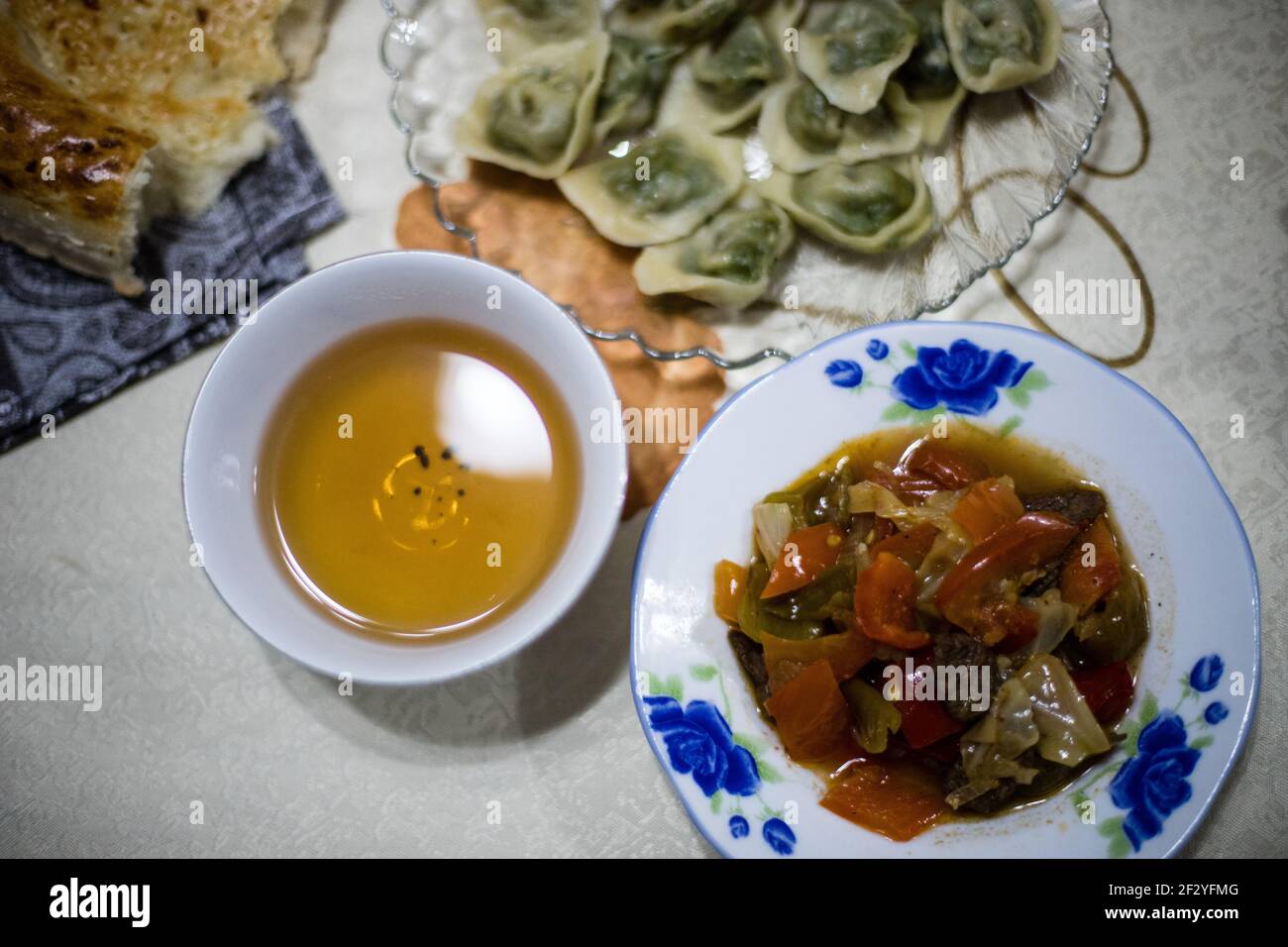 Cena con una famiglia Uyghur locale nella città di Karakol, nell'Issyk Kol Oblast del Kirghizistan. Foto Stock