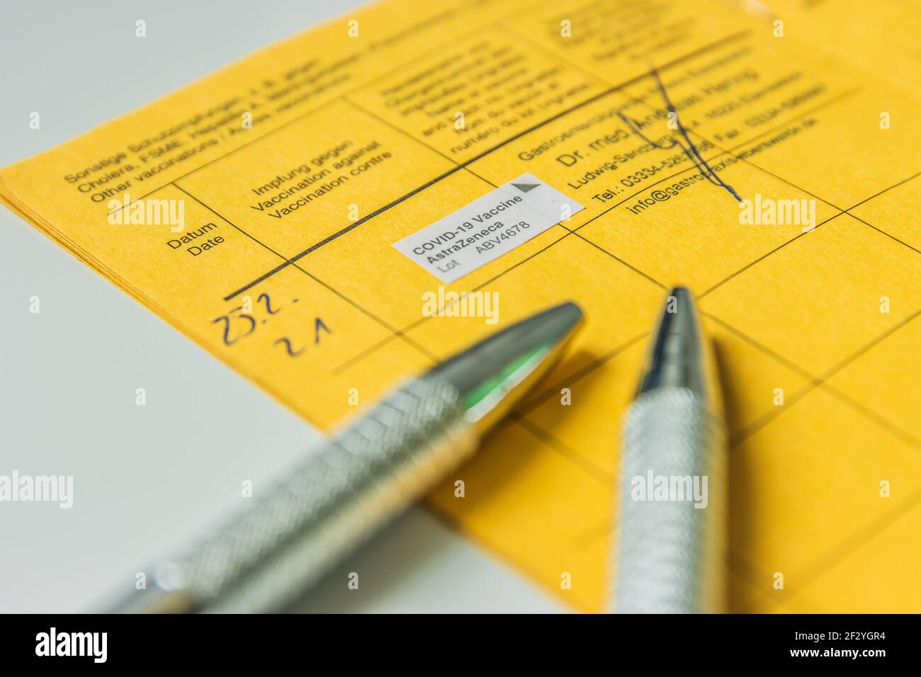 Estratto dal libro delle vaccinazioni con prova di vaccinazione contro il coronavirus. Due penne a sfera sulla pagina del libro di vaccinazione. Azienda medica con Foto Stock