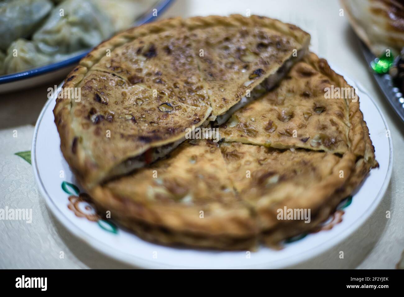 Cena con una famiglia Uyghur locale nella città di Karakol, nell'Issyk Kol Oblast del Kirghizistan. Foto Stock