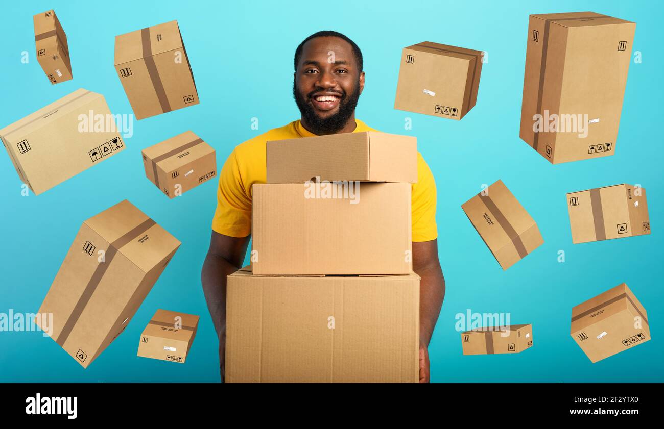 Happy boy riceve un sacco di pacchetti da ordine di negozio online. Sfondo blu. Foto Stock