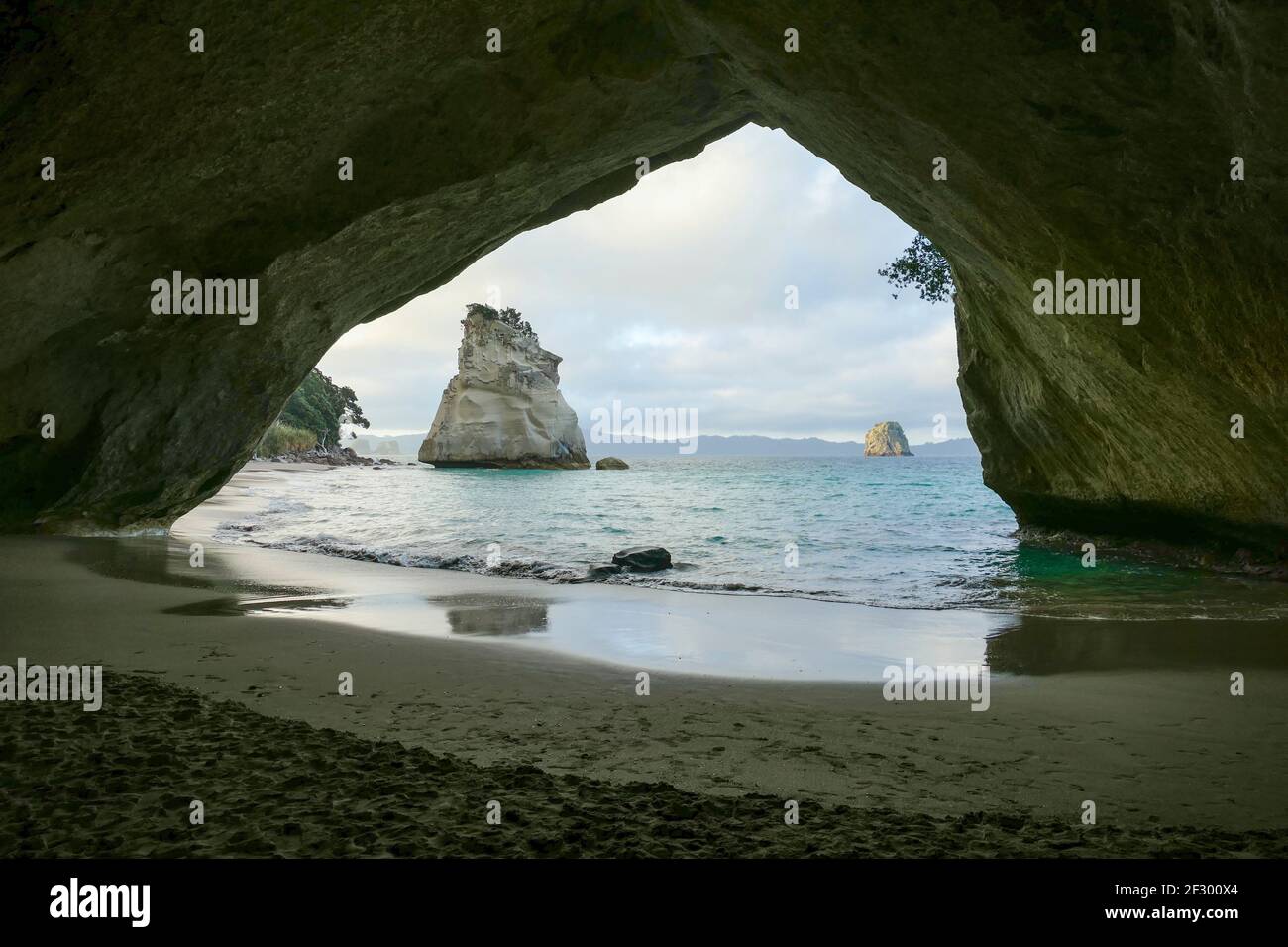 Te Hoho Rock visto attraverso un arco di roccia a a. Area costiera chiamata Cathedral Cove nella parte meridionale di Mercury Bay sulla penisola di Coromandel al No Foto Stock