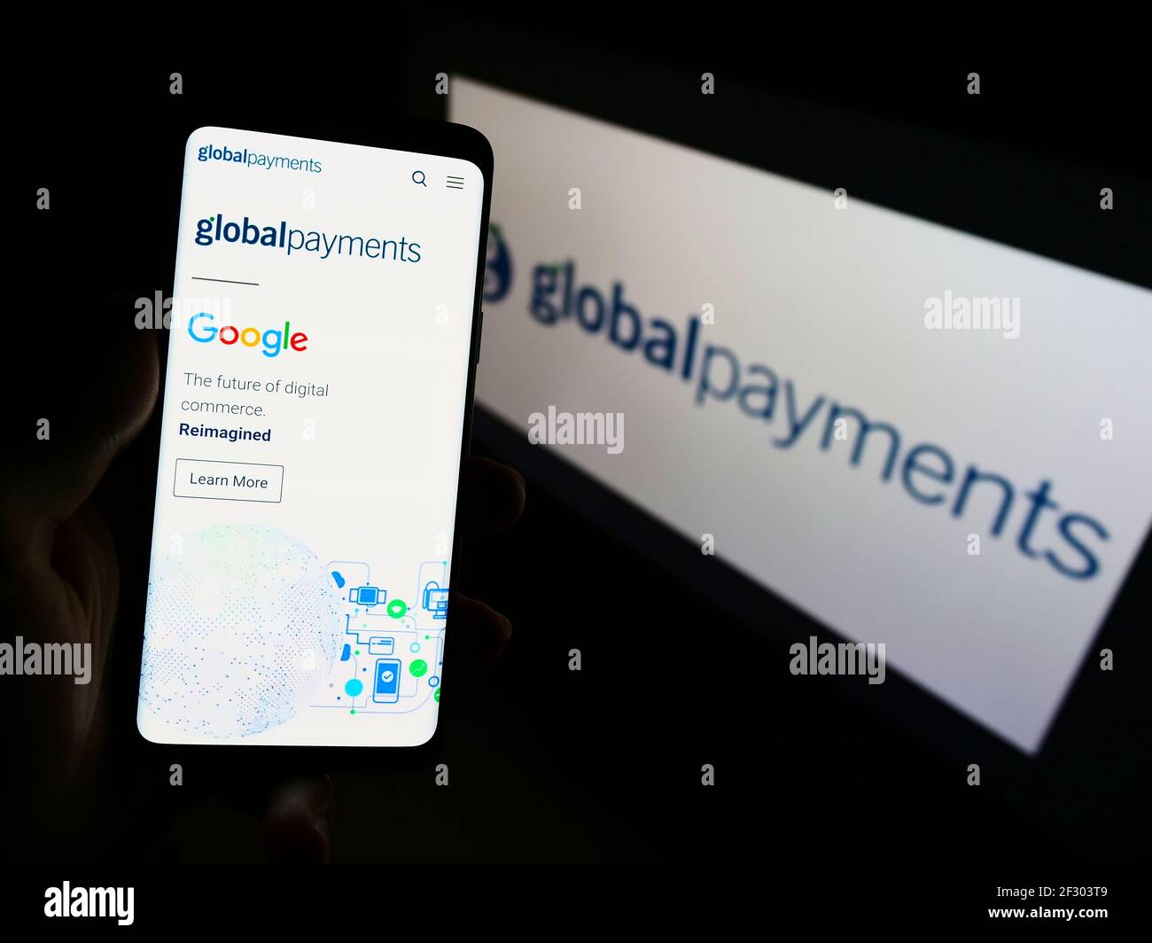 Persona che detiene il telefono cellulare con la pagina web del fornitore di pagamenti degli Stati Uniti Global Payments Inc. Sullo schermo davanti al logo. Mettere a fuoco il centro del display del telefono. Foto Stock