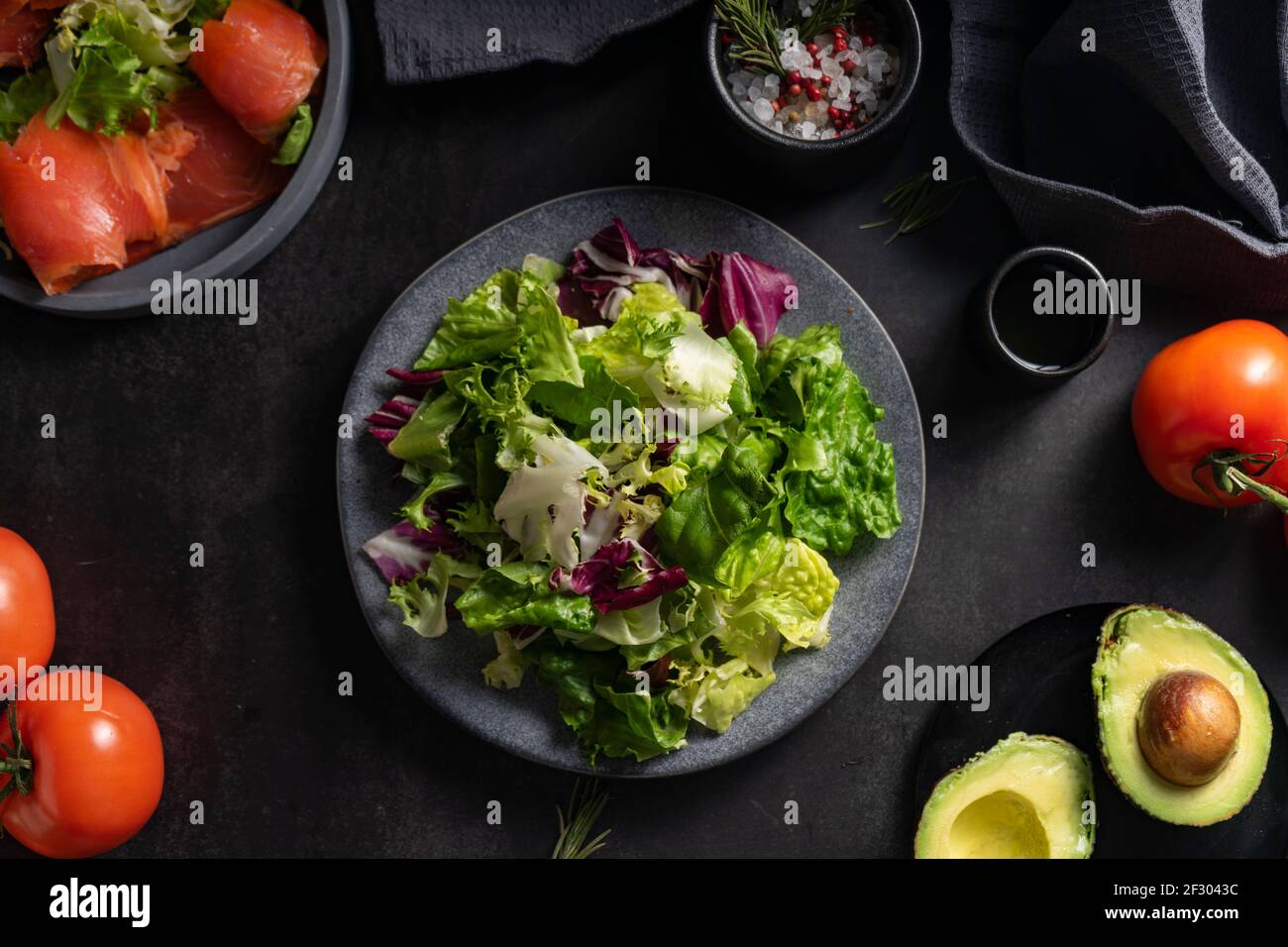 fuoco selettivo. insalata verde di erbe fresche, cibo naturale. su fondo scuro in basso. base per uno spuntino leggero Foto Stock