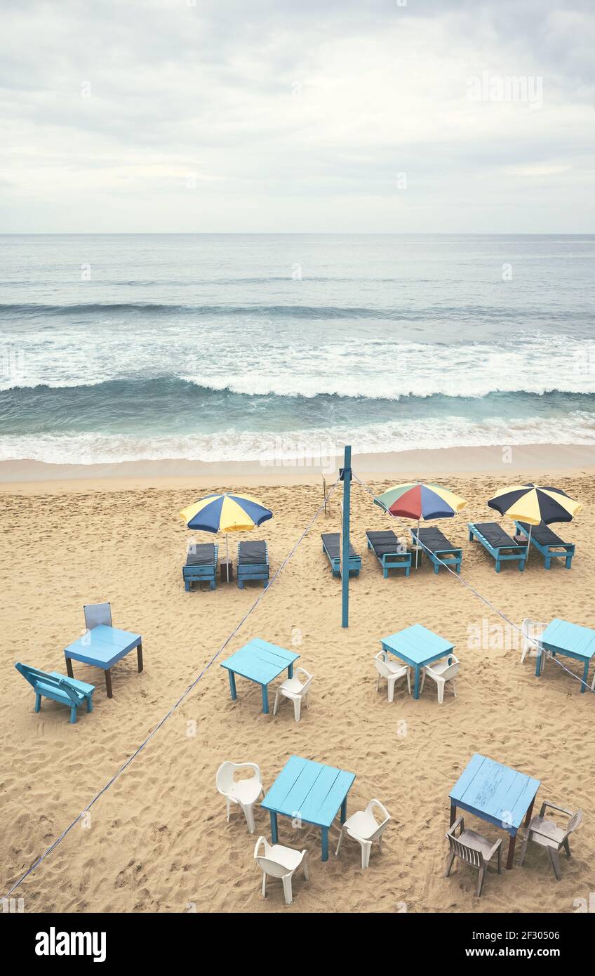 Vista aerea di una spiaggia tropicale vuota con ombrelloni, lettini, tavoli e sedie, tonalità cromatiche applicate, Sri Lanka. Foto Stock