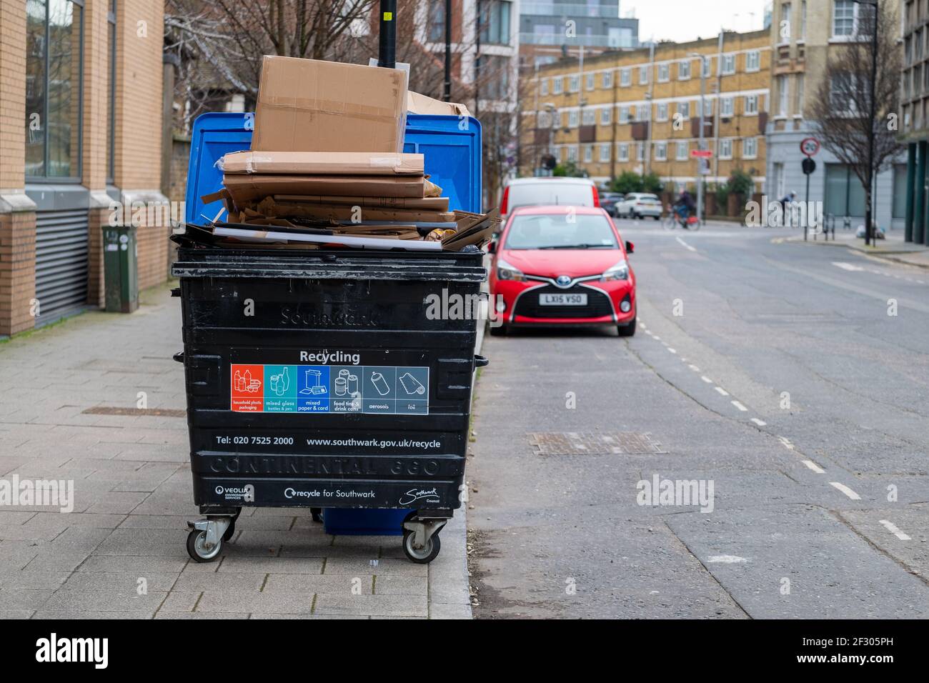 Londra UK Febbraio 2021 contenitore per il riciclaggio riempito di rifiuti nell'area di Southwark, scatole di cartone sopra il contenitore in attesa di essere ritirato Foto Stock