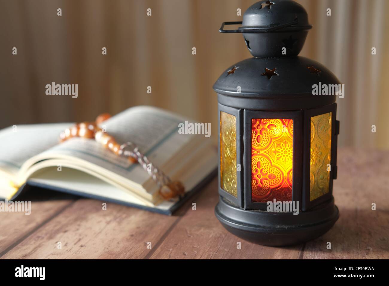 Libro santo Quran, rosario e lampada del leathern sul tavolo, Foto Stock