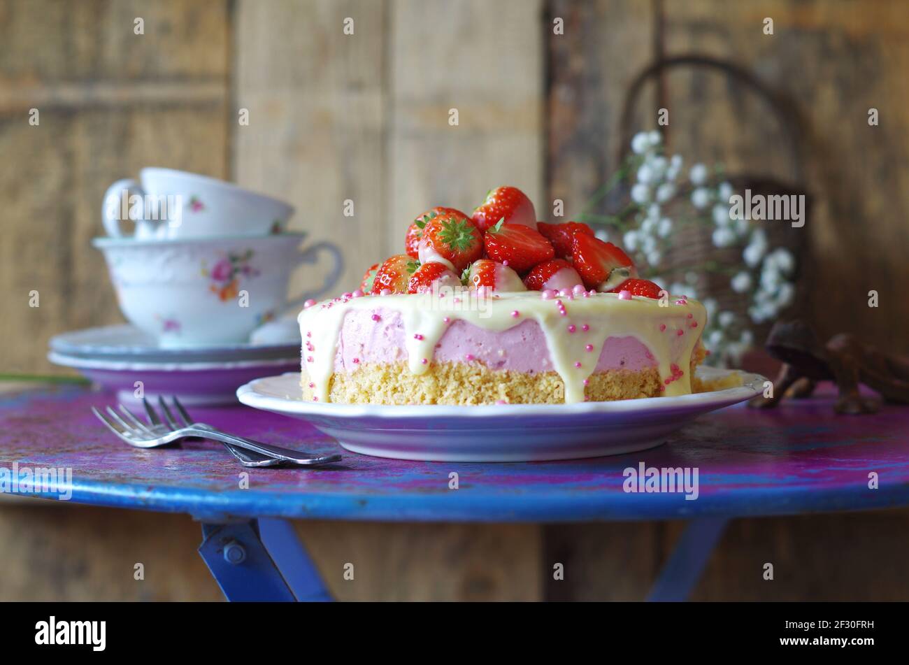 Torta alla crema di fragole con glassatura al cioccolato bianco e zucchero rosa spruzzare Foto Stock