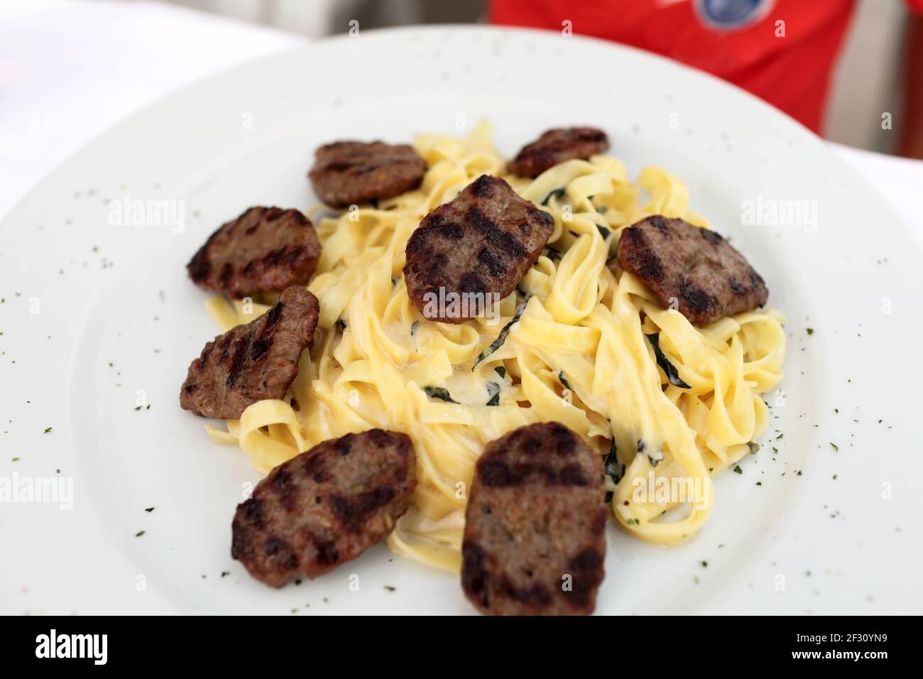 Tagliatelle con tagliatelle su un piatto bianco Foto Stock