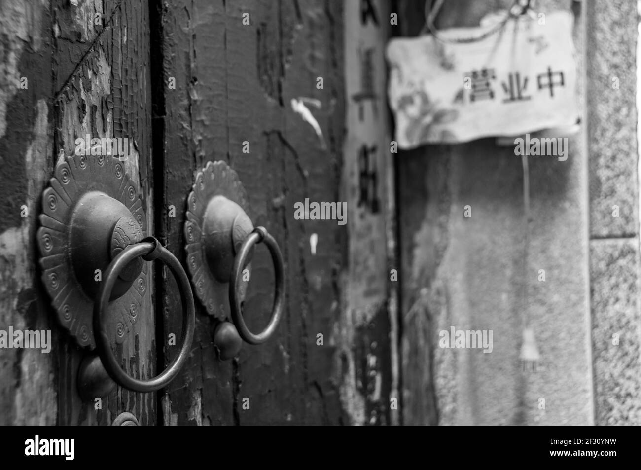 Maniglie in ottone tradizionali su una porta con vernice a peeling nel Tianzifang di Shanghai. Distretto di Huangpu, Shanghai, Cina, Asia. Foto Stock
