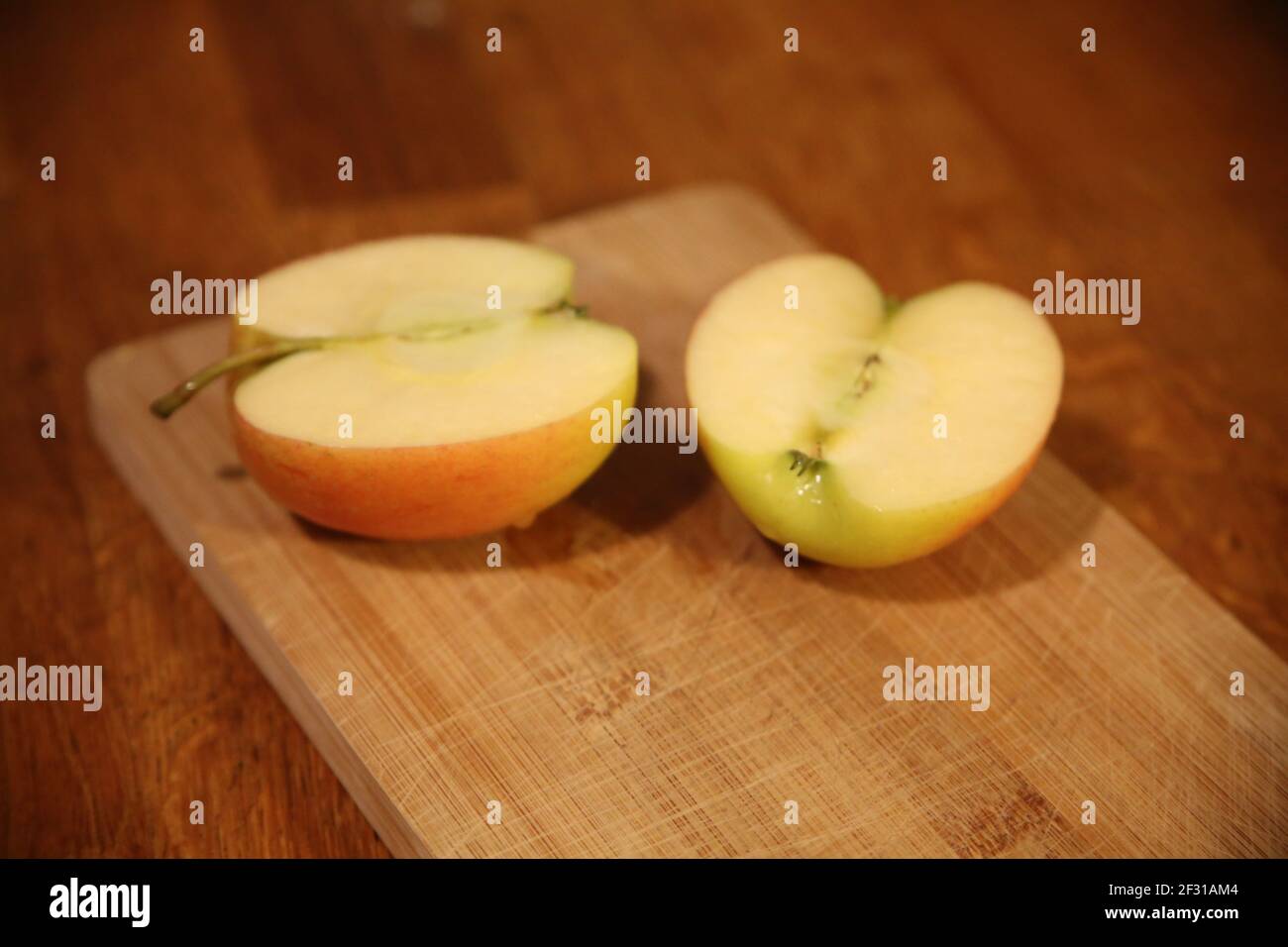 Due metà di una mela fresca succosa su un taglio scheda Foto Stock