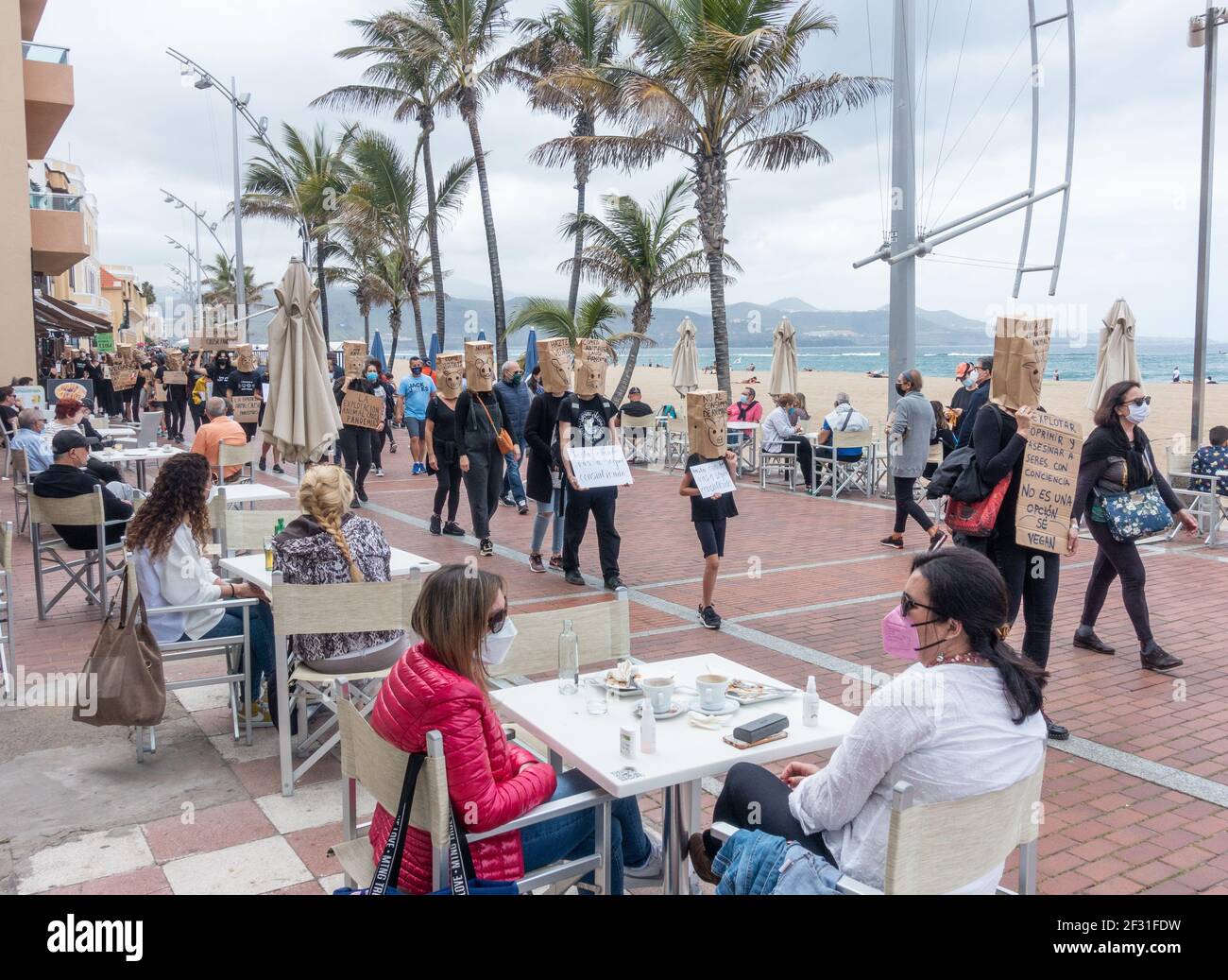 Las Palmas, Gran Canaria, Isole Canarie, Spagna. 14 Marzo 2021. I manifestanti sui diritti degli animali camminano davanti a ristoranti che si affacciano sulla spiaggia della città di Las Palmas, sulla Gran Canaria. Credit: Alan Dawson/Alamy Live News. Foto Stock