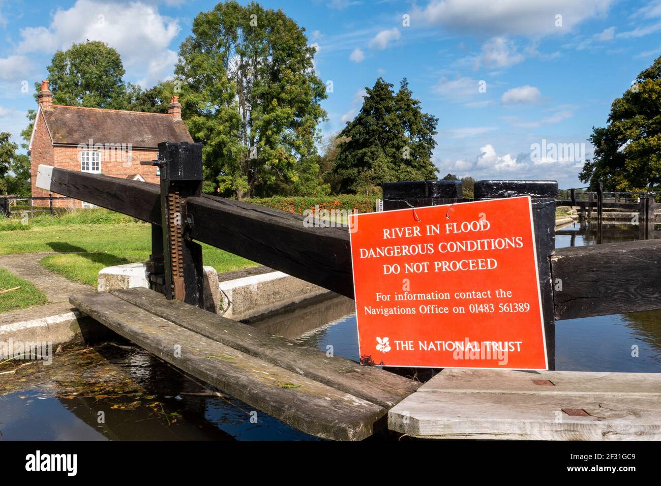 Fiume in Flood a River Wey Papercourt Lock con NT cartello rosso avvertenza: nessuna ulteriore navigazione a causa di pericoli Condizioni del fiume Ripley Surrey UK Foto Stock